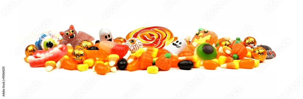 Fototapeta premium Long pile of colorful Halloween candy and sweets over a white background