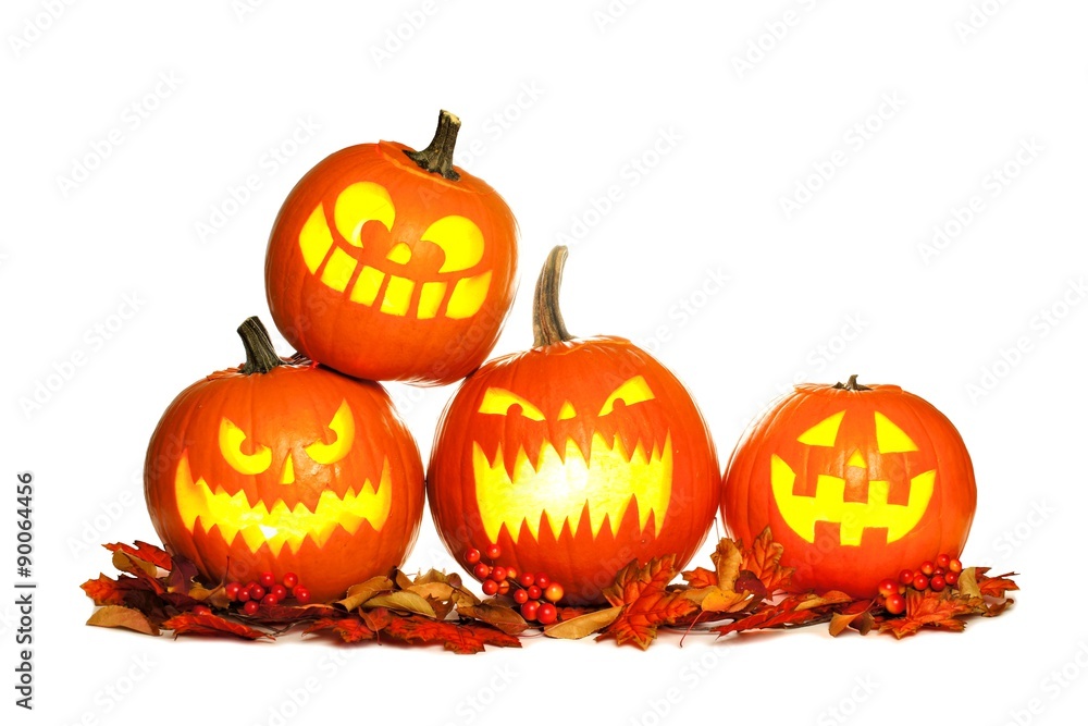 Group of fun lit Halloween Jack o Lanterns with autumn leaves isolated on a white background Group of fun lit Halloween Jack o Lanterns with autumn leaves isolated on a white background