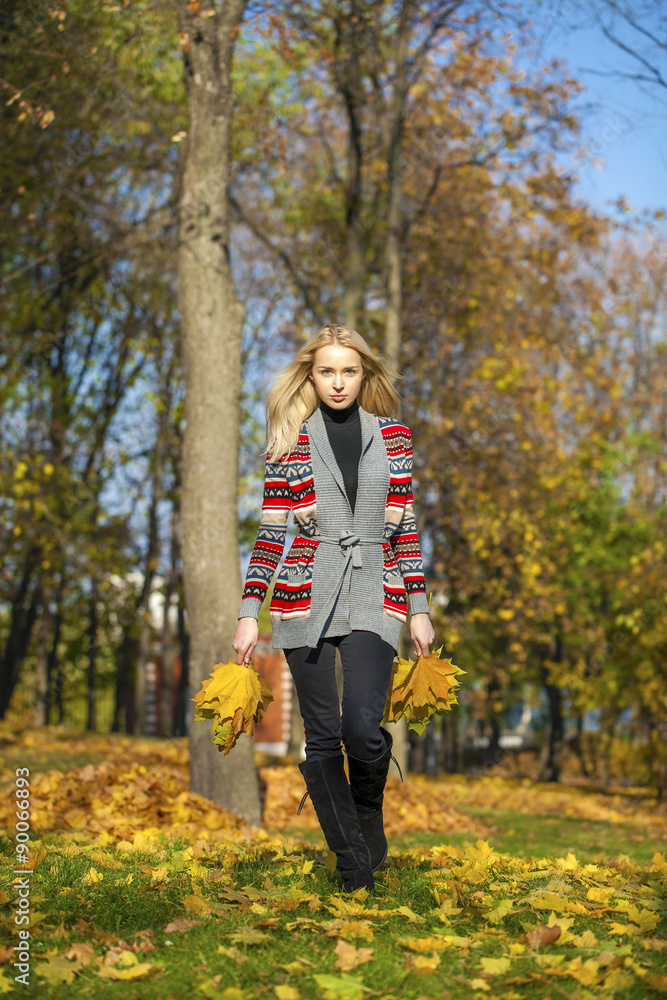 Happy Beautiful blonde woman walks in autumn park