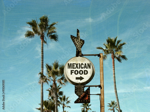 aged and worn vintage photo of mexican food sign with palm trees
