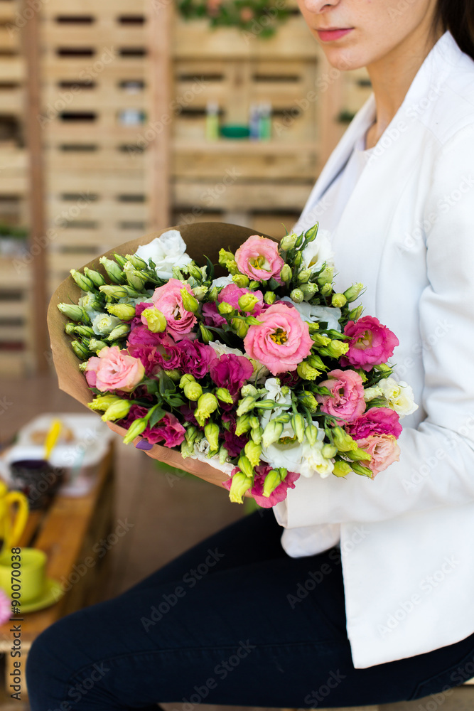 Paper cornet lisianthuses bouquet in hands of the girl Paper cornet lisianthuses bouquet in hands of the girl