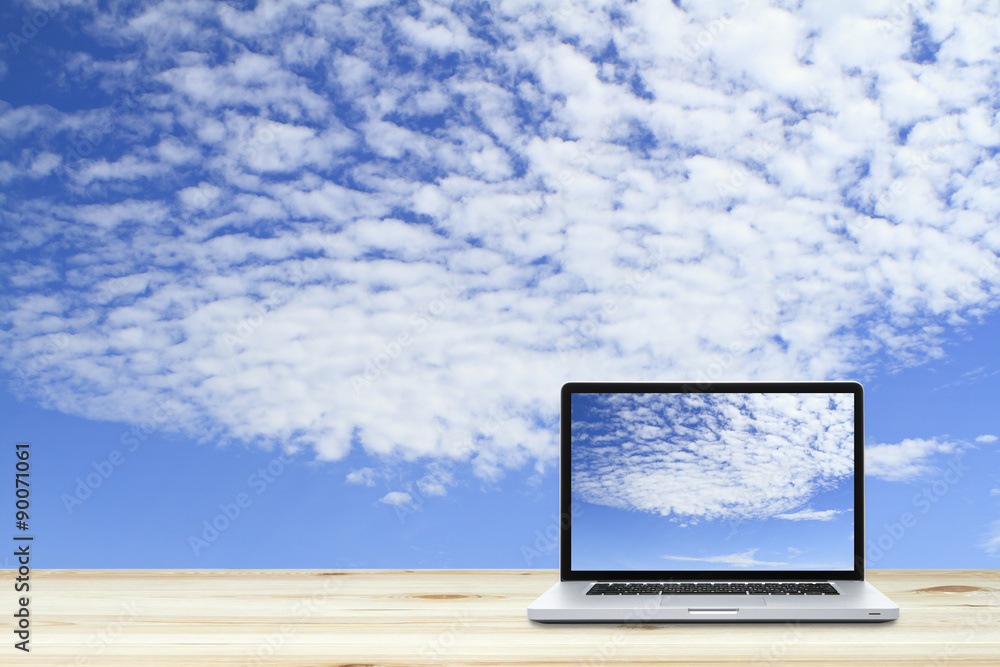 Laptop computer on wooden floor with sky background. Laptop computer on wooden floor with sky background.