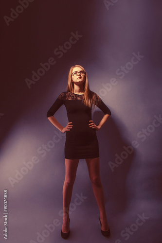 European-looking girl of twenty years in glasses, wearing a dres