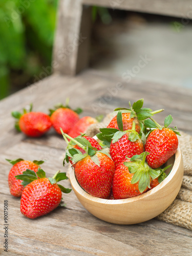 Fresh red strawberry in a wooden bowl
