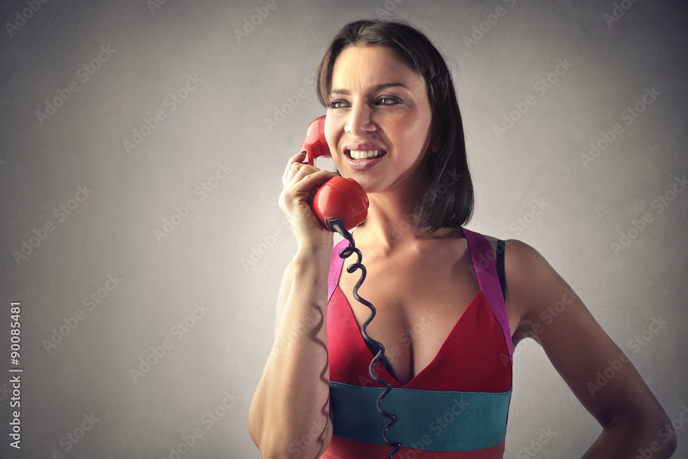 Woman using a old-fashioned red phone Woman using a old-fashioned red phone