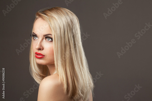 Fashion Stylish Beauty portrait of smiling beautiful blonde girl with professional make-up, false eyelashes and red lips in photostudio