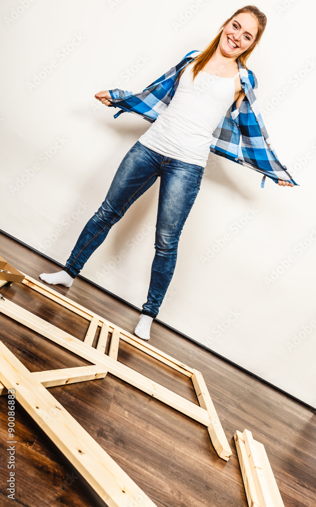Happy woman assembling wood furniture. DIY.