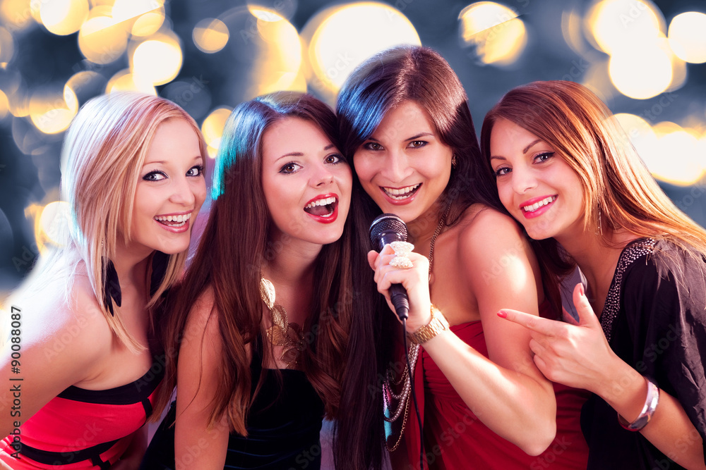 Four beautiful girls singing karaoke