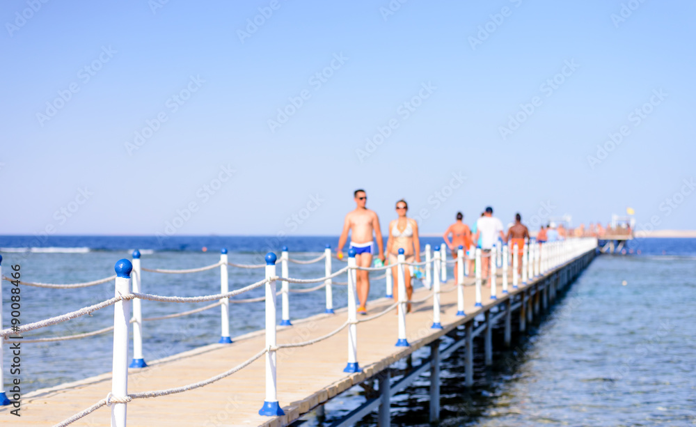 Tourists walking across a wooden pier