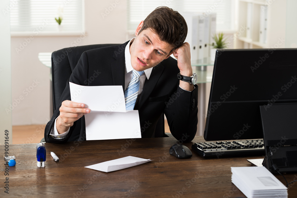 Shocked Businessman With Document In Office Shocked Businessman With Document In Office