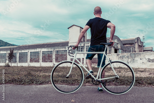Young man with a fixie bike. Decadent industrial setting © irantzuarb