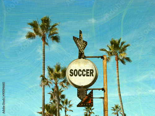 aged and worn vintage photo of soccer sign with palm trees
