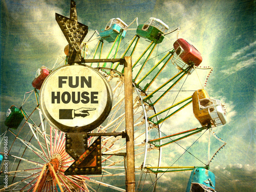 aged and worn vintage photo of fun house sign with ferris wheel