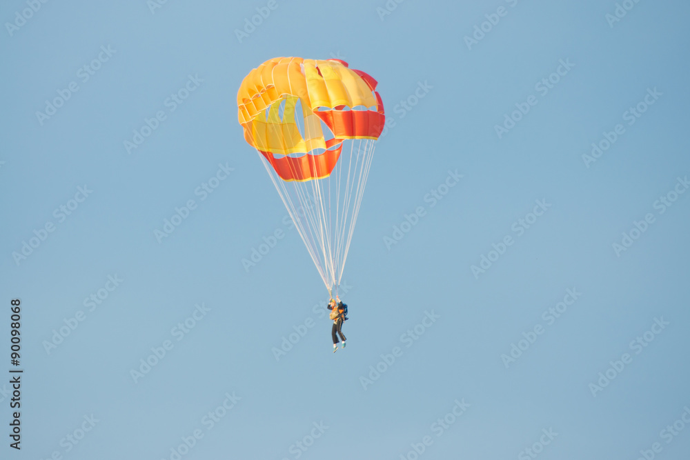 Parachutist in bright yellow-orange parachute parachute Parachutist in bright yellow-orange parachute parachute
