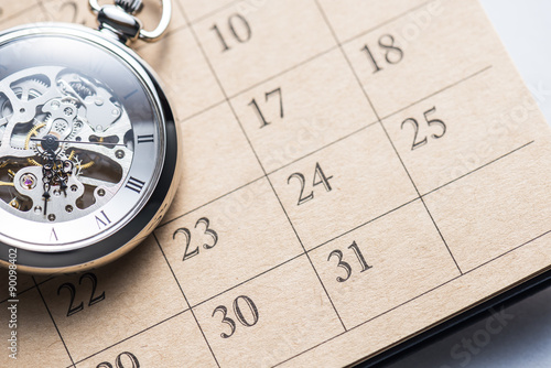 Pocket watch on calendar.