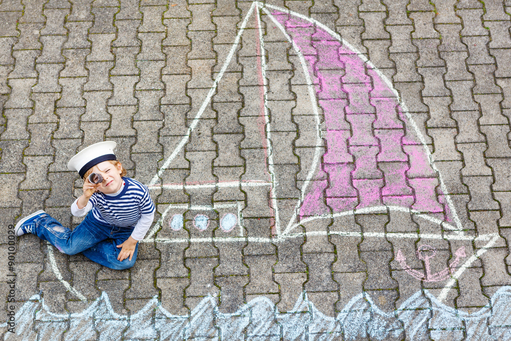 Little kid boy having fun with ship picture drawing with chalk Little kid boy having fun with ship picture drawing with chalk