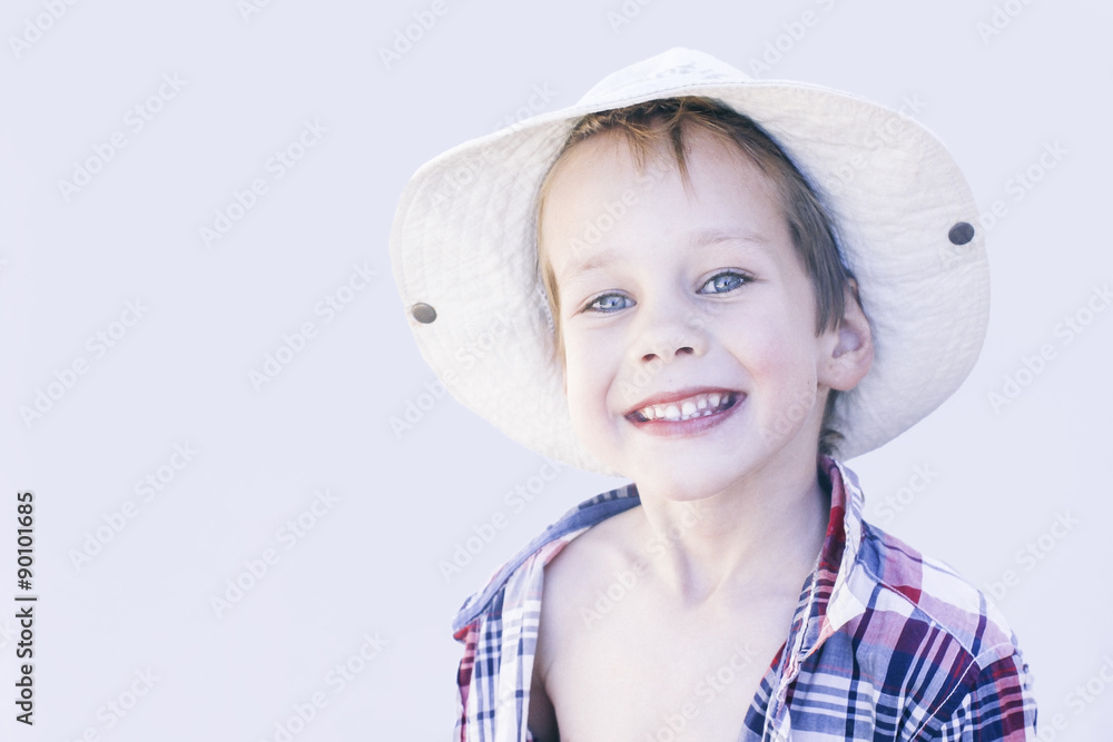 smile all over her face. smiling happy boy wearing a plaid shirt and a wide-brimmed hat smile all over her face. smiling happy boy wearing a plaid shirt and a wide-brimmed hat