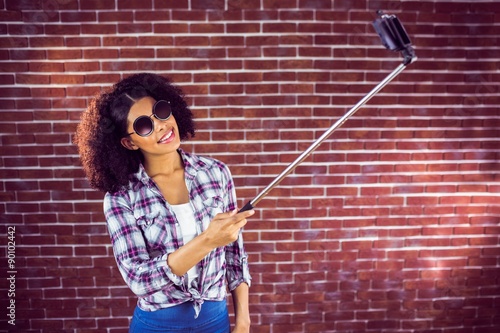 Attractive hipster taking selfies with selfiestick photo