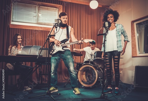 Multiracial music band performing in a recording studio © Nejron Photo