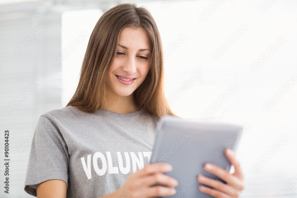 Smiling brunette volunteer using tablet Smiling brunette volunteer using tablet