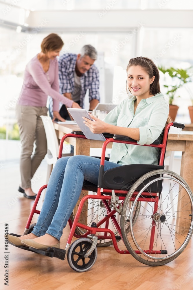 Casual businesswoman in wheelchair using tablet Casual businesswoman in wheelchair using tablet