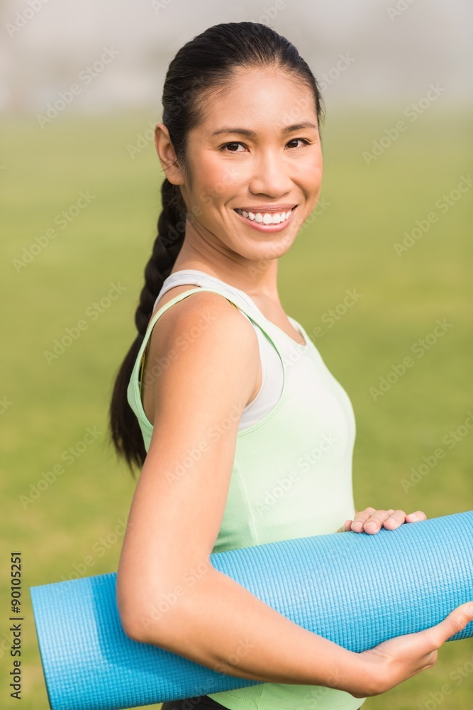 Smiling sporty woman holding exercise mat Smiling sporty woman holding exercise mat