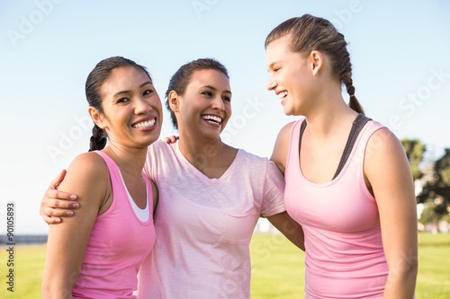 Smiling woman and friends wearing pink for breast cancer