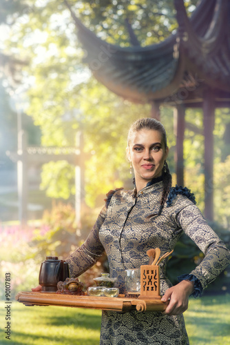 Female tea master making Chinese tea ceremony in garden photo