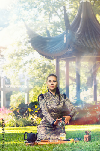 Female tea master making Chinese tea ceremony in garden photo