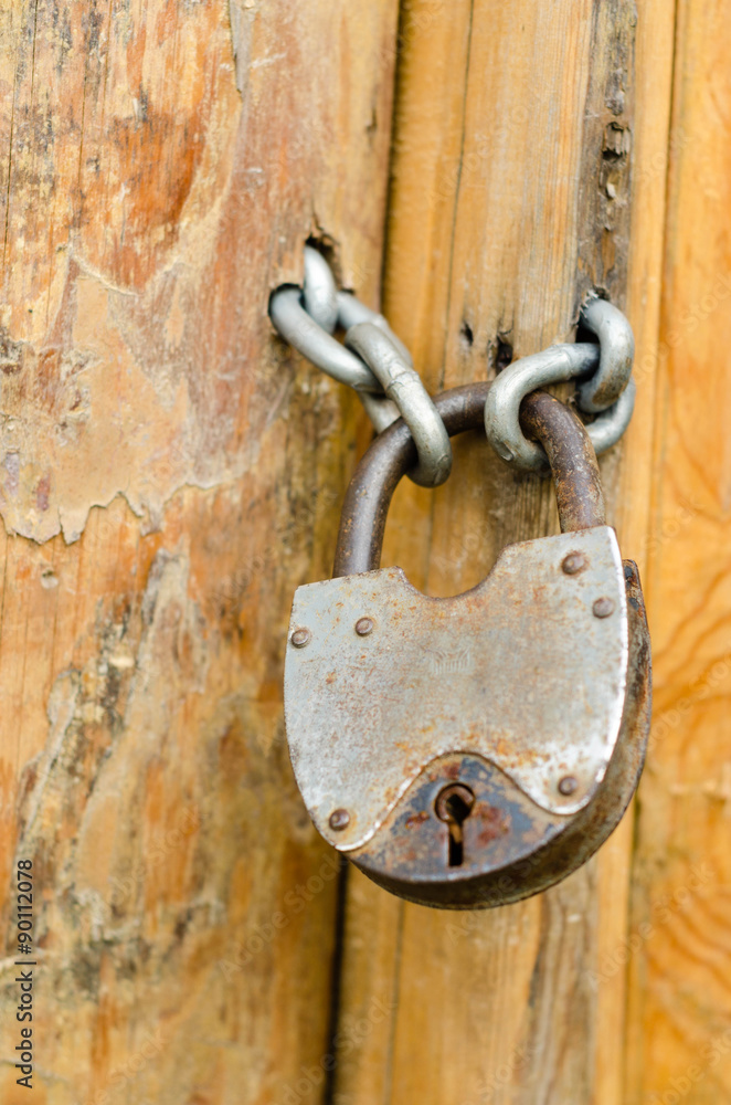 Old rustic padlock on the wooden door Old rustic padlock on the wooden door