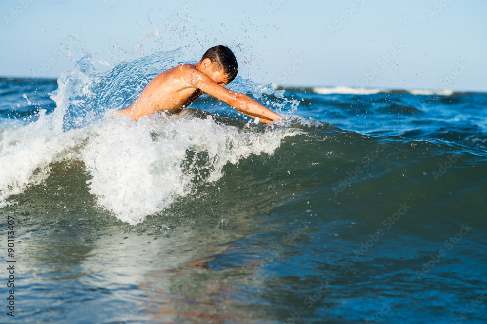 Teenager  boy enjoying a swimming in the sea.