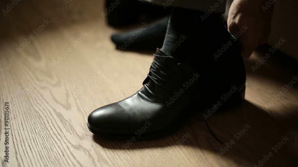 Man putting on his leather shoes Man putting on his leather shoes