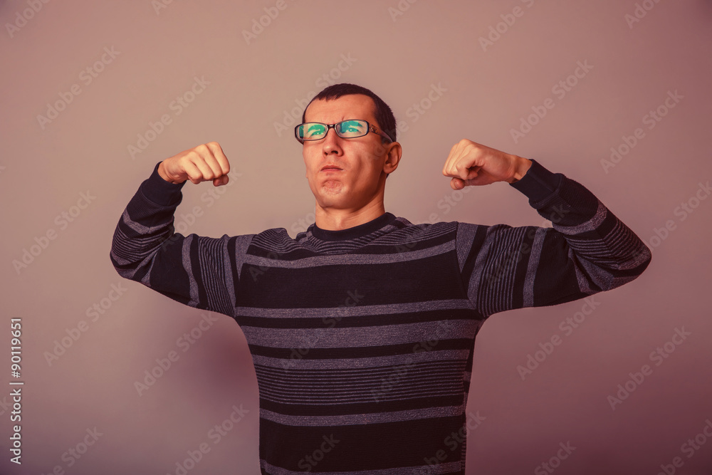 Naklejka premium European-looking male of about thirty brunet shows muscle streng