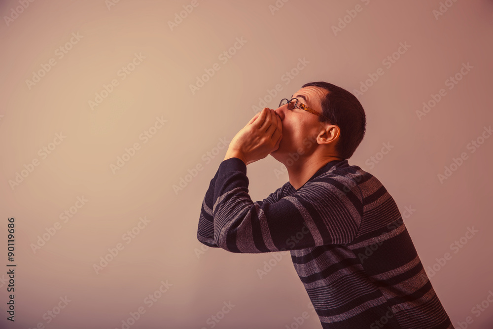 European-looking male put his hands to his mouth, shouting on gr European-looking male put his hands to his mouth, shouting on gr