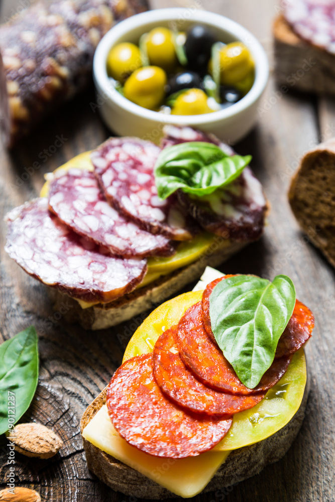 Sandwiches with salami, basil and olives