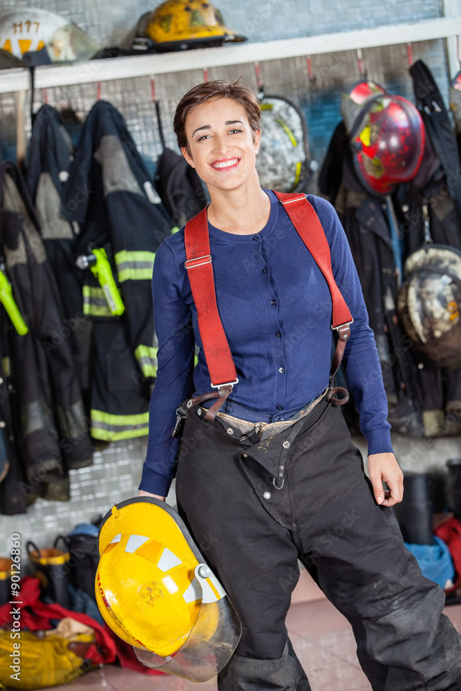 Obraz premium Firewoman Holding Helmet At Fire Station