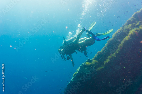 Scuba Diver on coral reef in clear blue water
