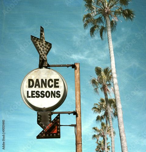 aged and worn vintage photo of dance lesson sign and palm trees