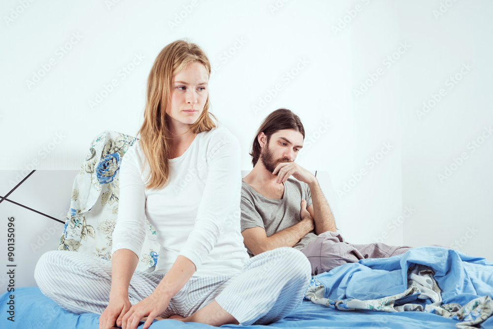 young caucasian couple in bed discussing their problems young caucasian couple in bed discussing their problems