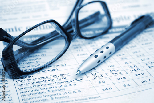 ballpoint pen and glasses on finance report 