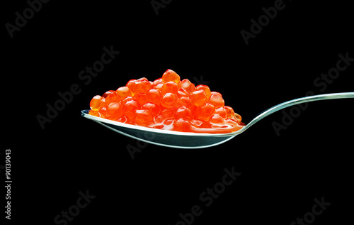 spoon of red caviar on black background