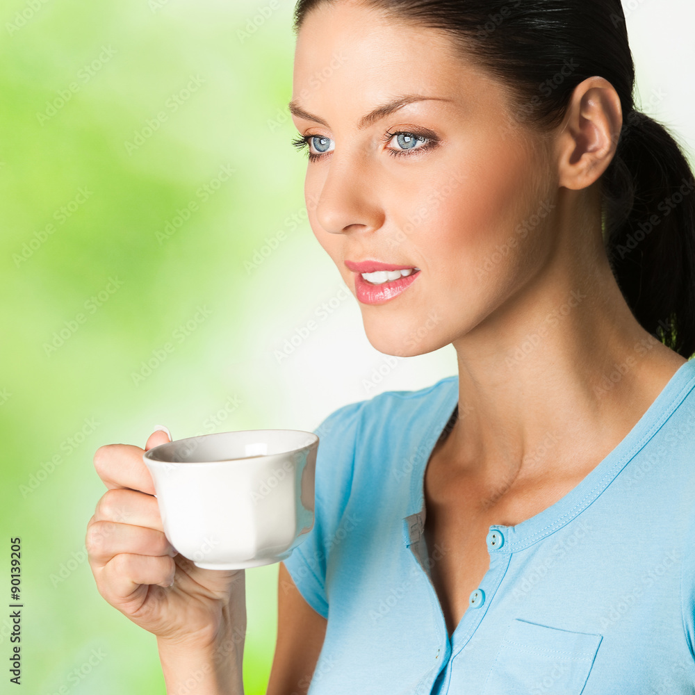 Young happy smiling woman drinking coffee, outdoors Young happy smiling woman drinking coffee, outdoors