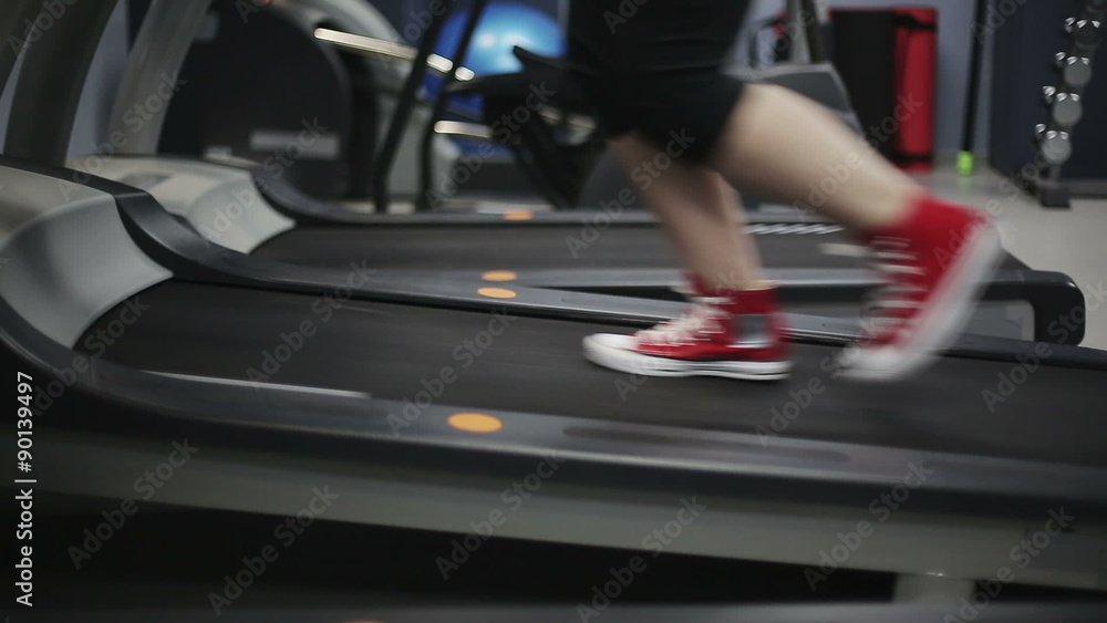 Close up woman's legs in red sneakers on a treadmill in the gym. Slider camera movement left to right Close up woman's legs in red sneakers on a treadmill in the gym. Slider camera movement left to right
