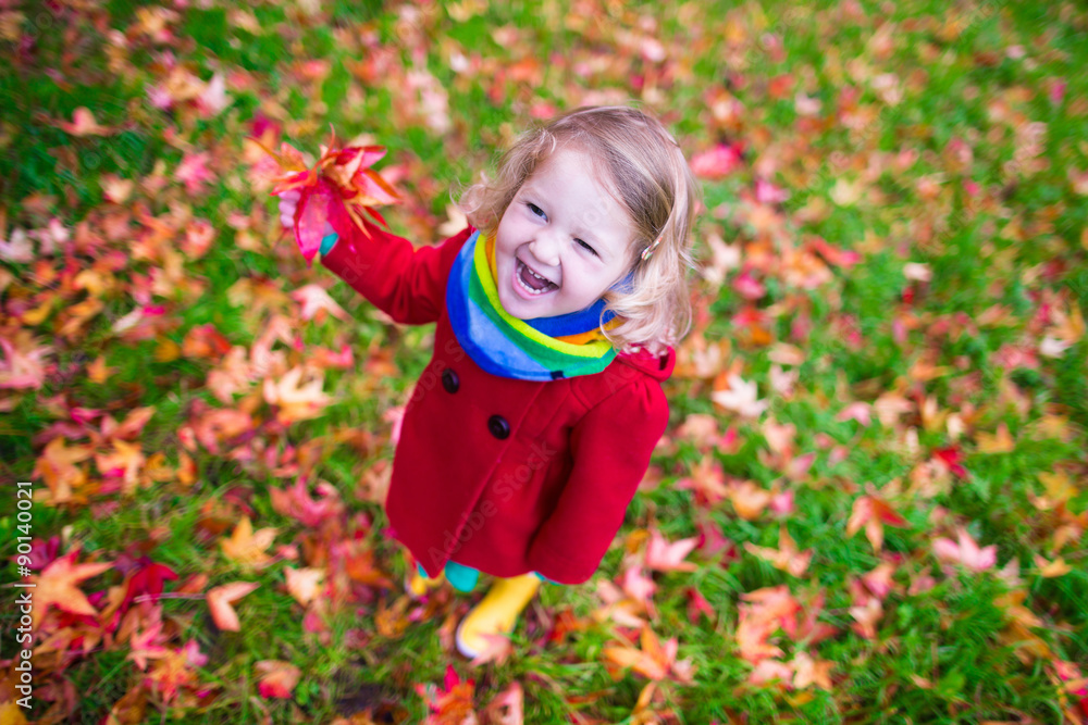 Little girl playing with maple leaf in autumn Little girl playing with maple leaf in autumn