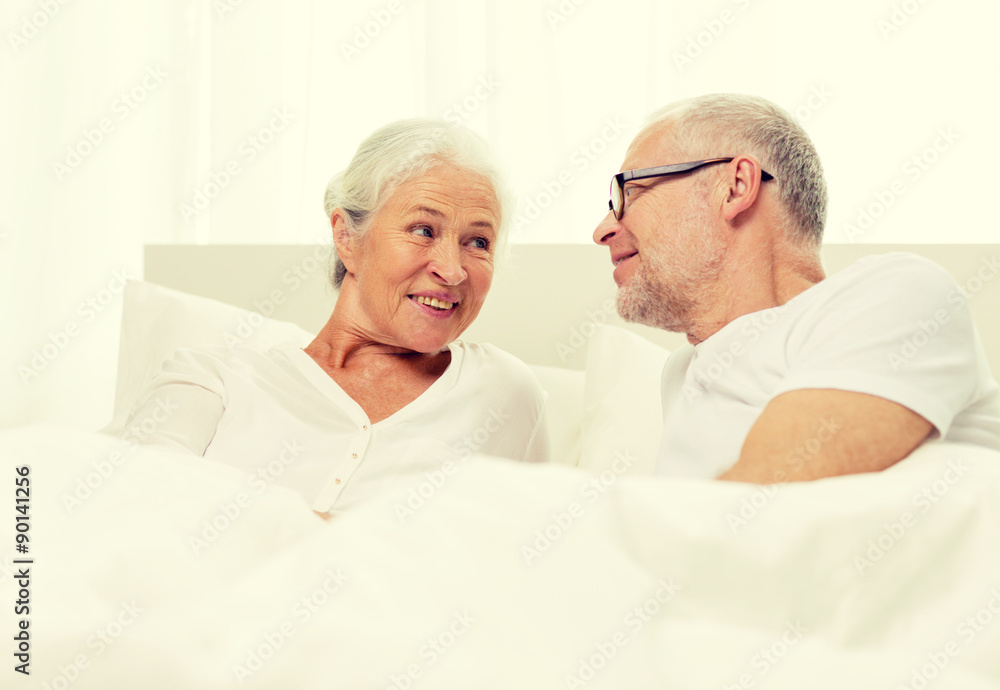 happy senior coupler lying in bad at home happy senior coupler lying in bad at home