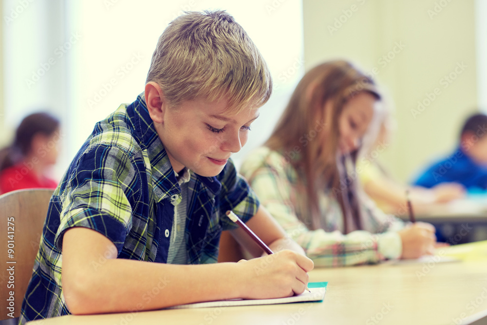 group of school kids writing test in classroom group of school kids writing test in classroom