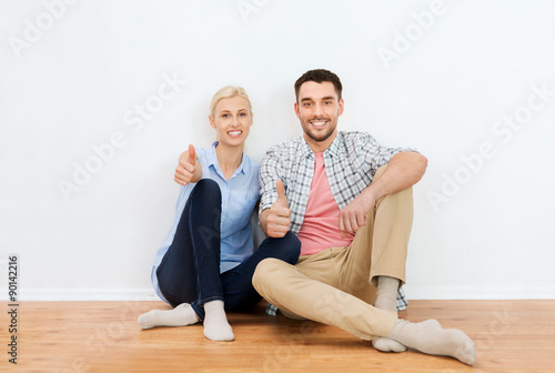 happy couple showing thumbs up at new home