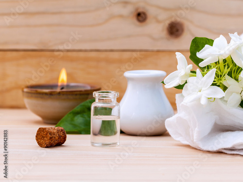 Aroma oil bottles arranged with jasmine flowers on wooden backgr