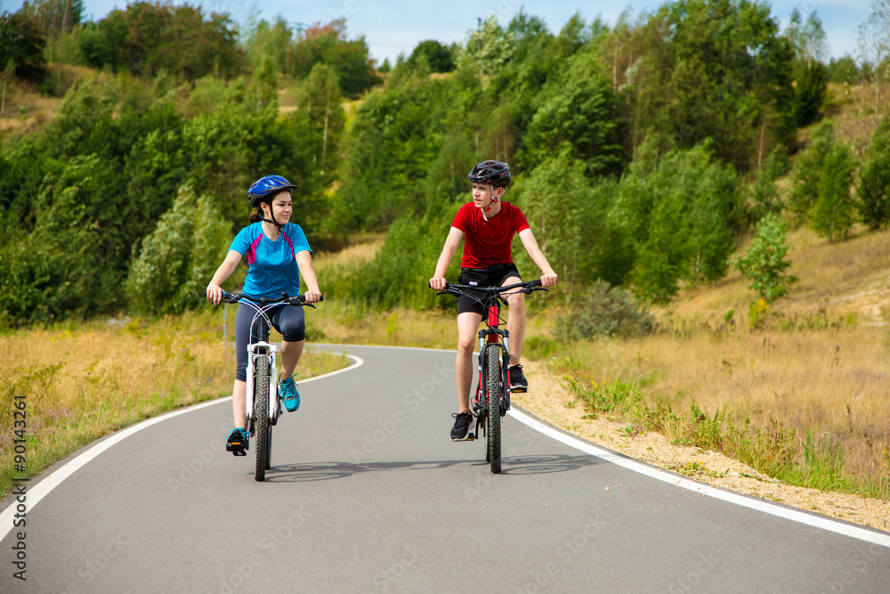 Healthy lifestyle - teenage girl and boy cycling 