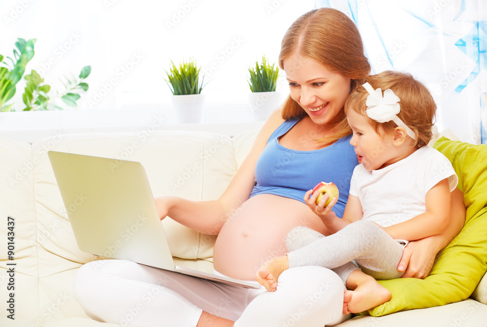 Happy family pregnant woman and child with a laptop at home Happy family pregnant woman and child with a laptop at home